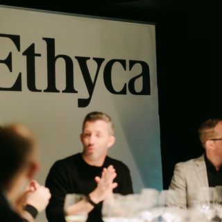 People sitting around a table in front of an Ethyca banner.