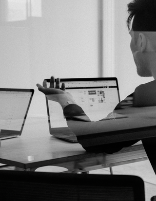 two-men-sitting-at-a-table-working-on-a-laptop