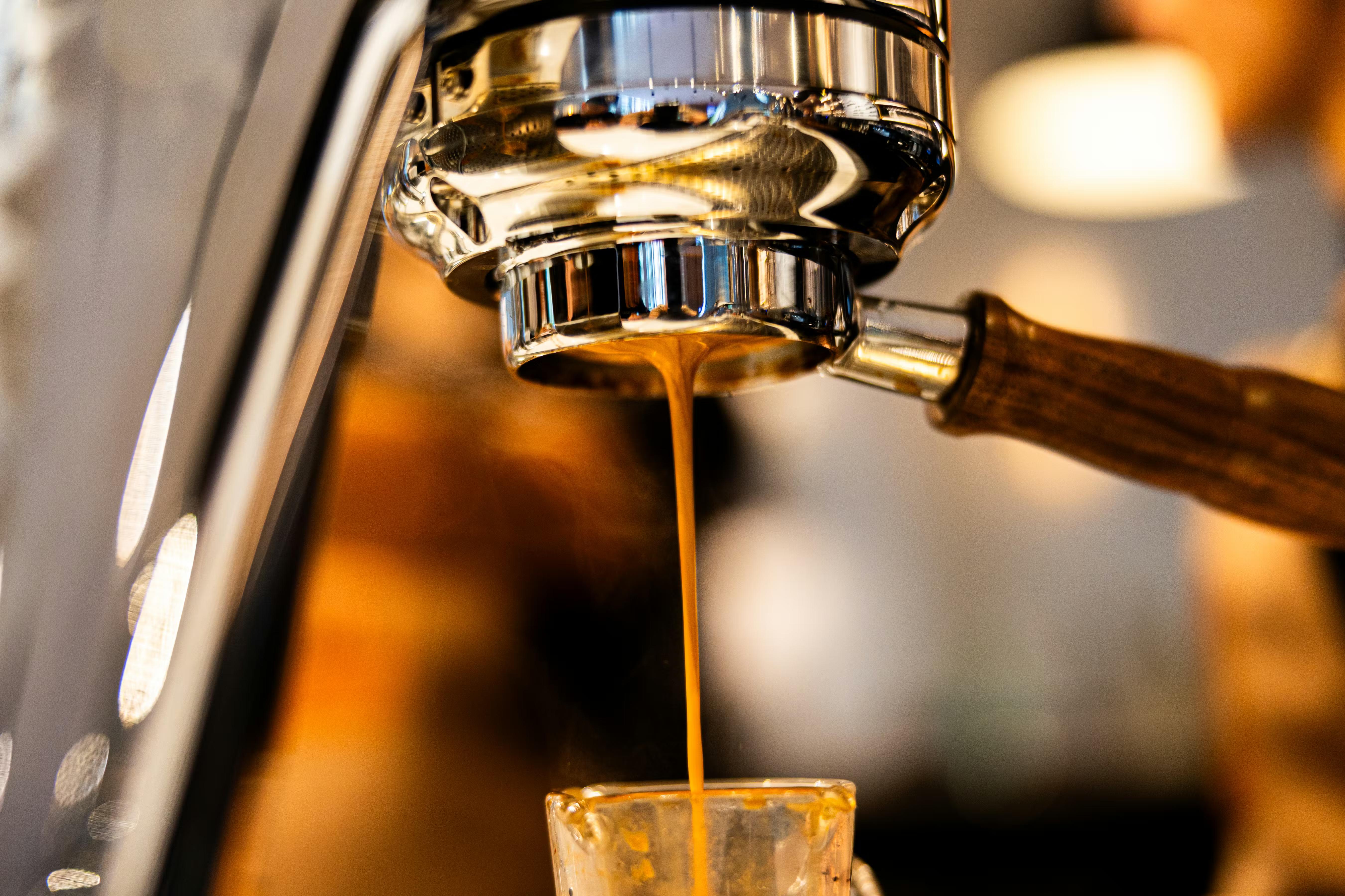 Espresso being poured through a machine, close up photograph.