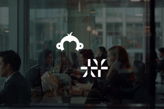 Modern office with focused employees working at computers, featuring glass walls and a collaborative atmosphere.