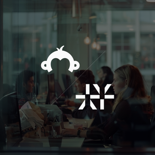 Modern office with focused employees working at computers, featuring glass walls and a collaborative atmosphere.