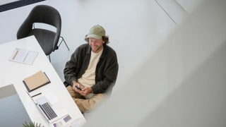 Man using his phone at a desk in a clean corporate office.