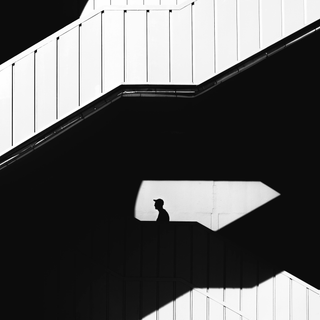 Silhouette of man behind wall on stairs