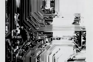 Monochromatic close-up of a circuit board with intricate pathways and components, showcasing the precision of electronic design