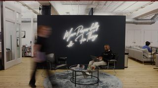 A loft startup office with people walking and working.