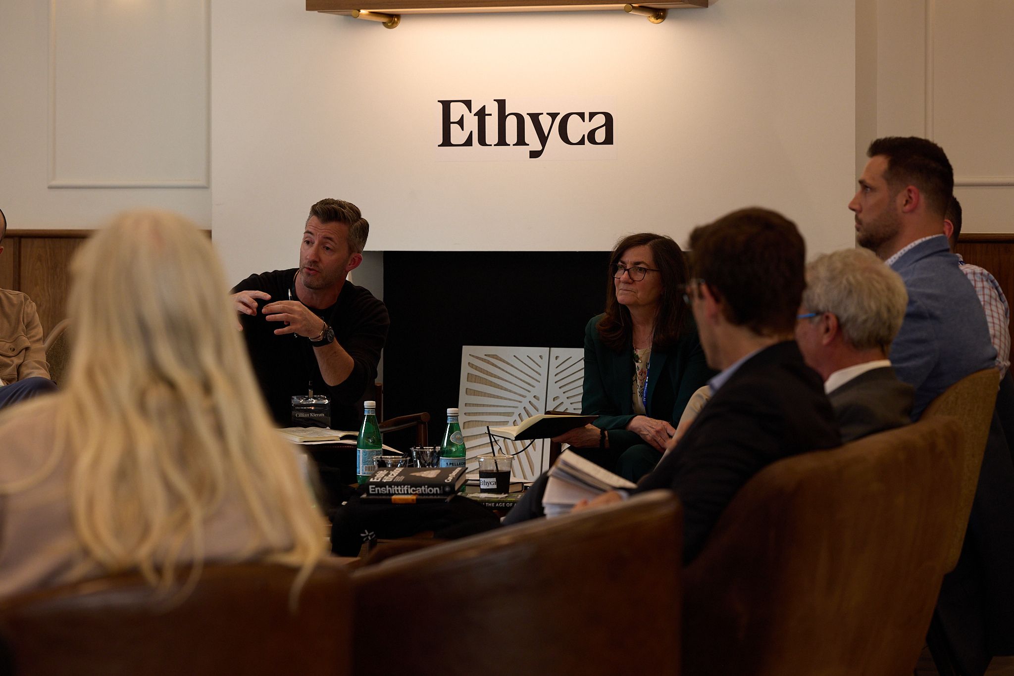 People talking in a circle in front of an Ethyca logo.