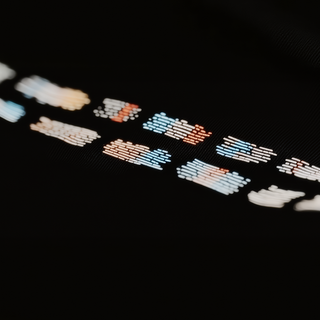 Abstract glowing rectangular patterns in white, orange, and blue on a dark background, evoking a futuristic and tech-inspired aesthetic.
