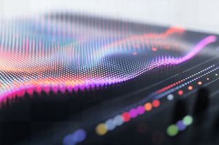 Vibrant digital wave visualization with multicolored dots on a dark surface, evoking futuristic data or sound analysis