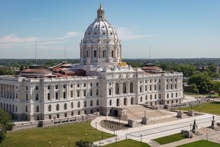 Photograph of the Minnesota Saint Paul capitol building with blue sky and green trees.