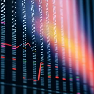 Close-up of a stock market screen with numerical data, colorful highlights, and a red line graph, set against a dark background