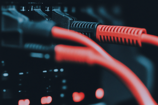 Neatly organized red network cables in a modern server rack, highlighting efficient cable management in a professional data center.