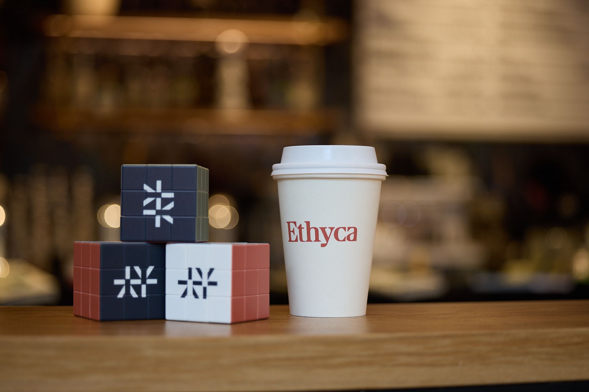 Rubiks cubes with Ethyca logo and Ethyca branded cup.