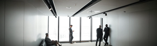 a-man-in-gray-suit-standing-near-glass-window-in-the-office