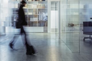 Blurred figure walking in a modern office