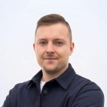 Robin Csipke, Inhaber von Keno Medien, Porträt in dunkelblauem Hemd vor hellem Hintergrund