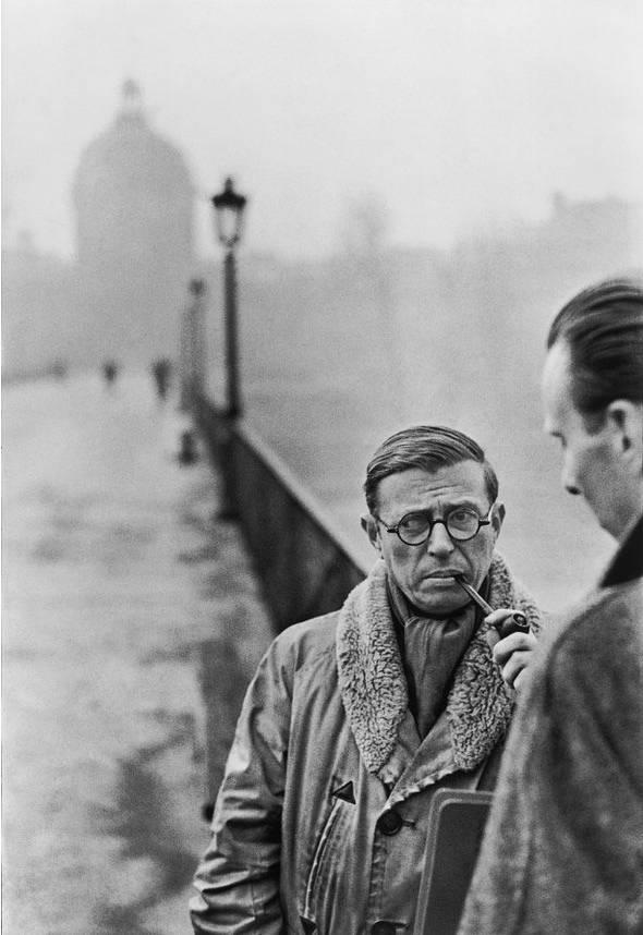Portrait of the philosopher Jean-Paul Sartre with a pipe on a bridge in Paris
