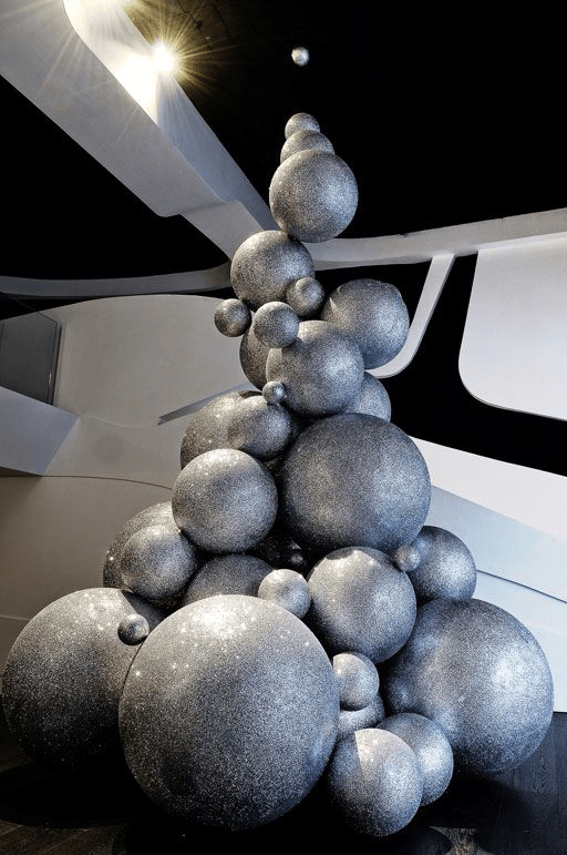 A festive installation of silvery balls arranged in a cone shape in an interior