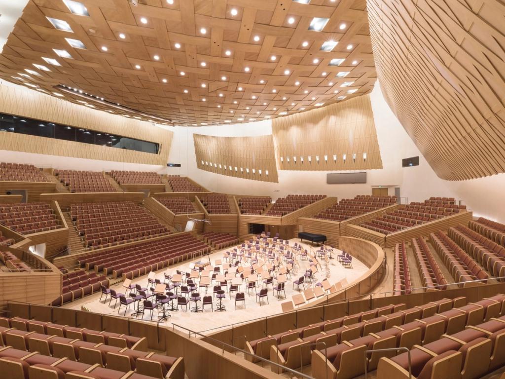 The wooden interior of the Shanghai Symphony Hall, with an amphitheatre arranged around the stage and orchestra chairs