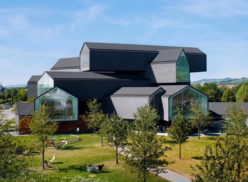 VitraHaus Herzog & de Meuron из составленных тёмных объёмов в форме домиков днём