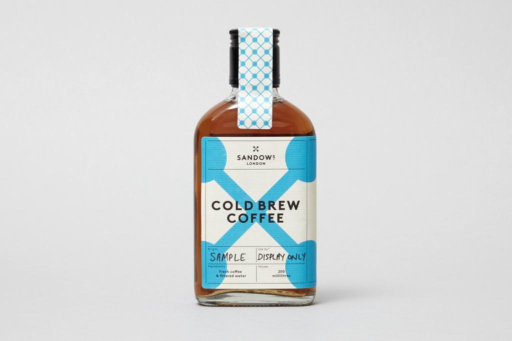 Бутылка холодного кофе Sandows London с белой этикеткой и голубым крестом