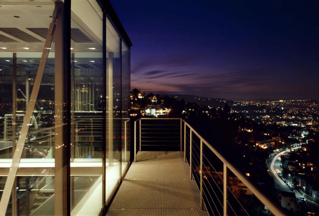 The terrace of house R-128 at night, overlooking the city lights below
