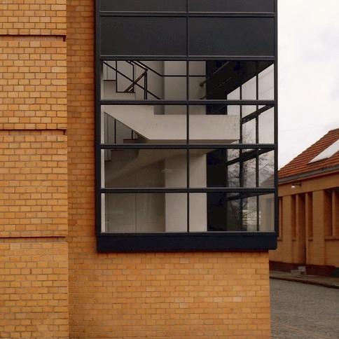 The glazed curtain-wall corner of the Fagus Factory, with the interior staircase visible behind the glazing