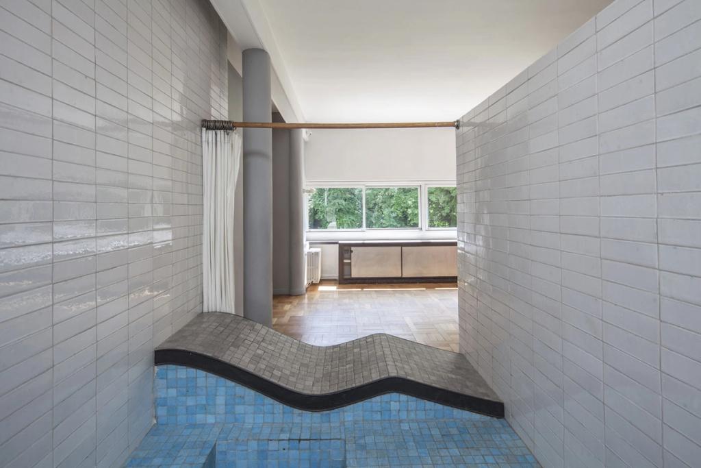 The bathroom of Villa Savoye with a wave-shaped recliner clad in blue mosaic