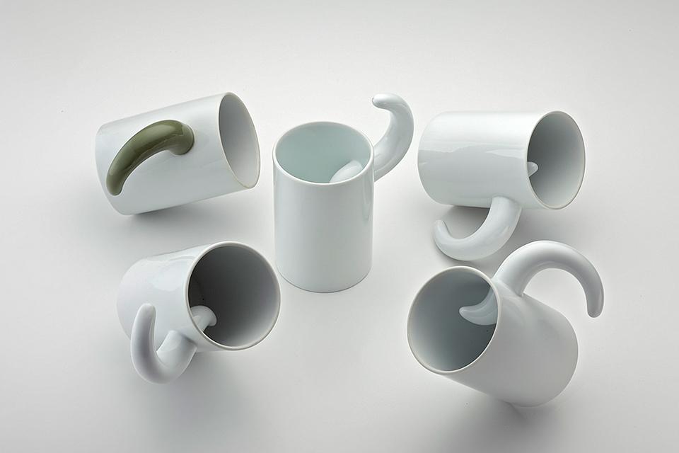 Five porcelain mugs with curved hook handles in different shades
