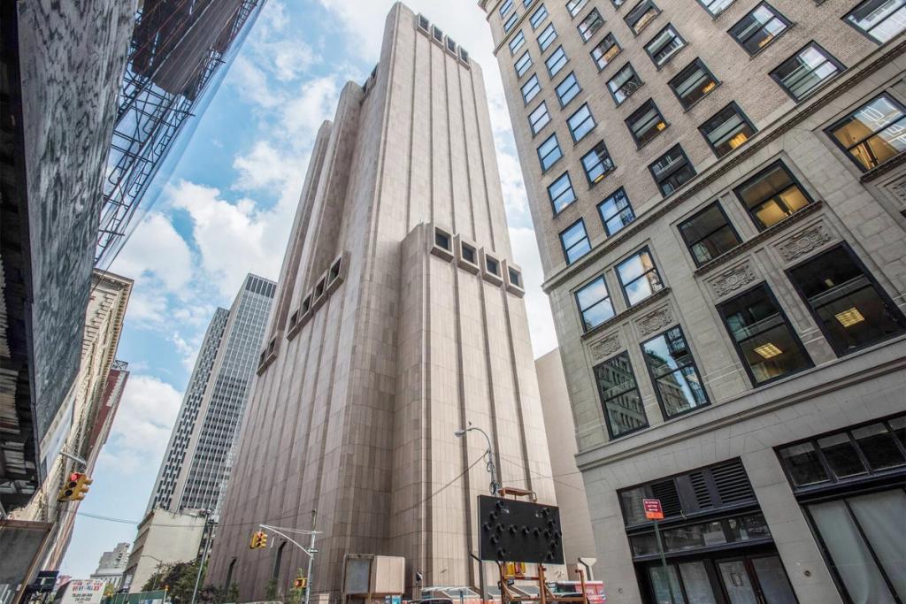 Глухая бетонная башня без окон AT&T Long Lines Building среди зданий нижнего Манхэттена