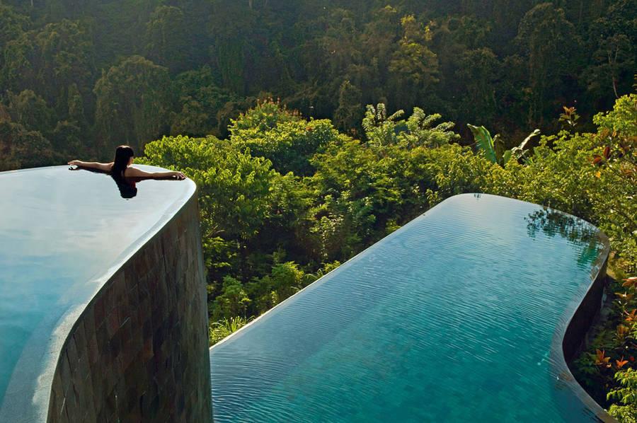 Женщина в многоуровневом бесконечном бассейне Ubud Hanging Gardens на фоне джунглей Бали