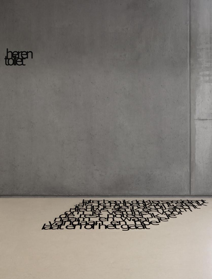 The concrete wall of Panta Rhei School featuring a Dutch typographic inscription and letters on the floor