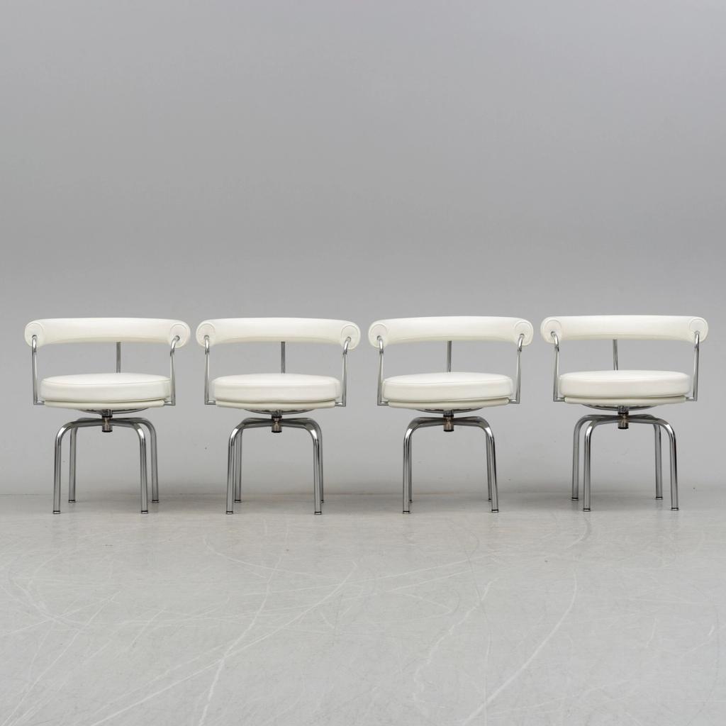 Four rotating LC7 armchairs by Charlotte Perriand with white upholstery and chrome legs
