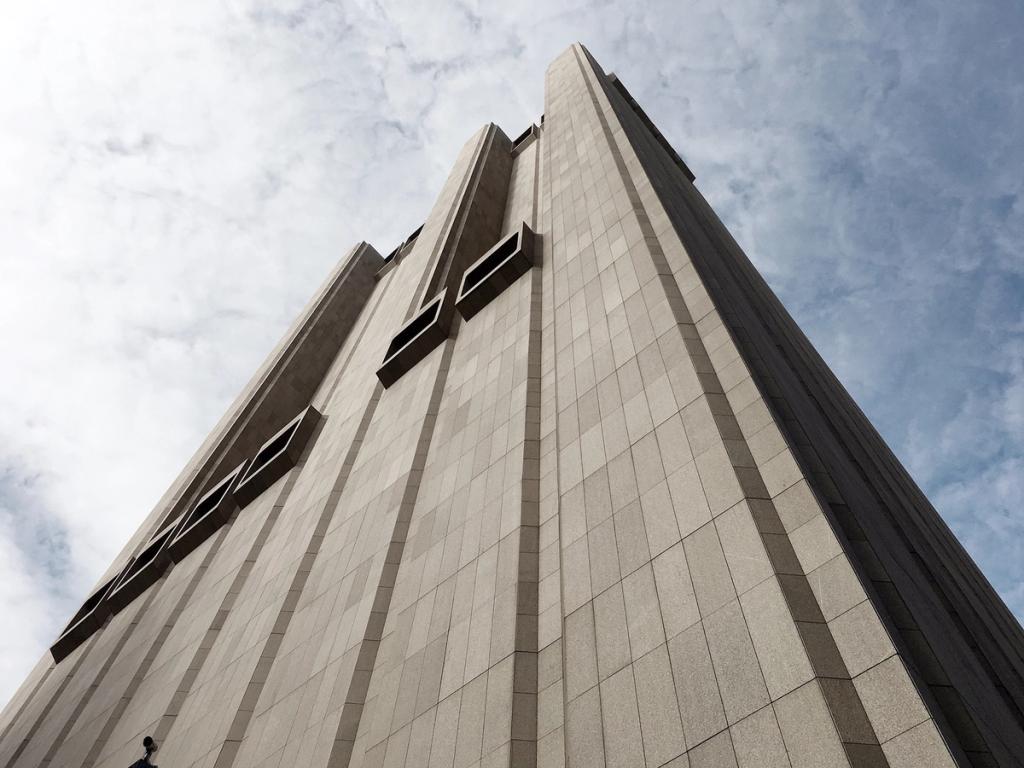 Вид снизу на ребристый бетонный фасад AT&T Long Lines Building с редкими вентиляционными проёмами