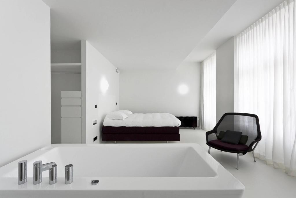 Сводчатый бассейн Hotel Zenden с бирюзовой водой, ступенями и белыми стенами