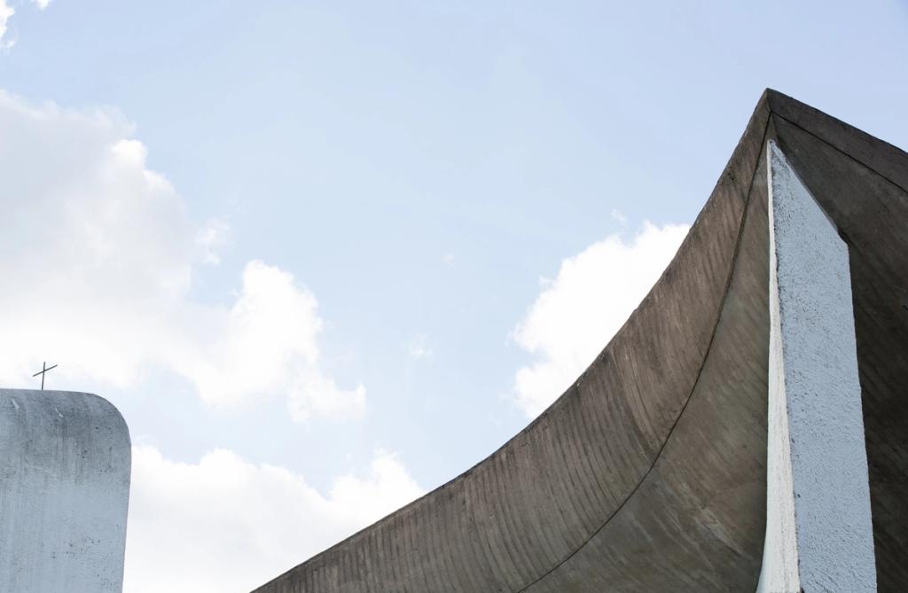 The Chapel of Ronchamp, a detail of the concave concrete roof and the tower with a cross