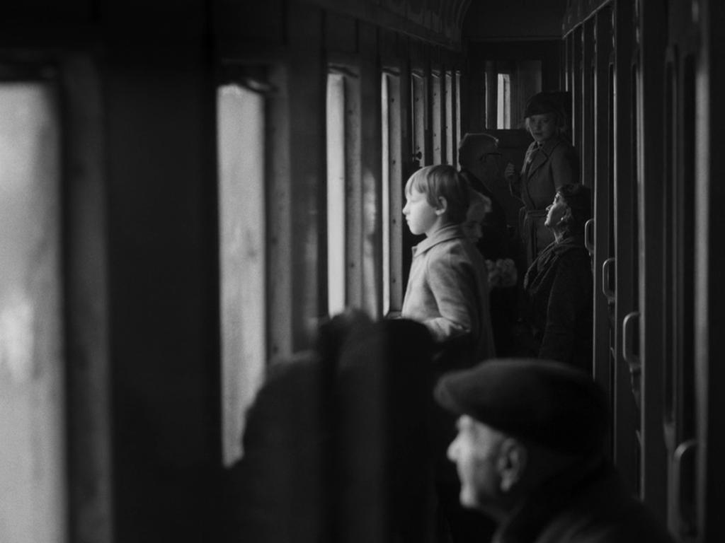 Мальчик и женщина у окон в коридоре старого поезда, мужчина на переднем плане