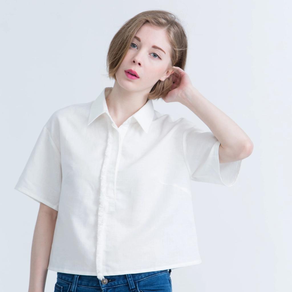 A model in a white short-sleeved cropped Kestan shirt against a light background