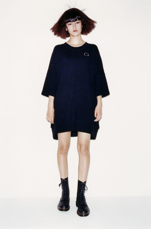 Portrait of a girl wearing a gold Hello Kitty ring and a patch on a black jumper