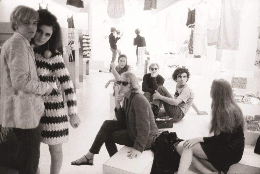 Black-and-white photograph of a group of young people in a clothing store