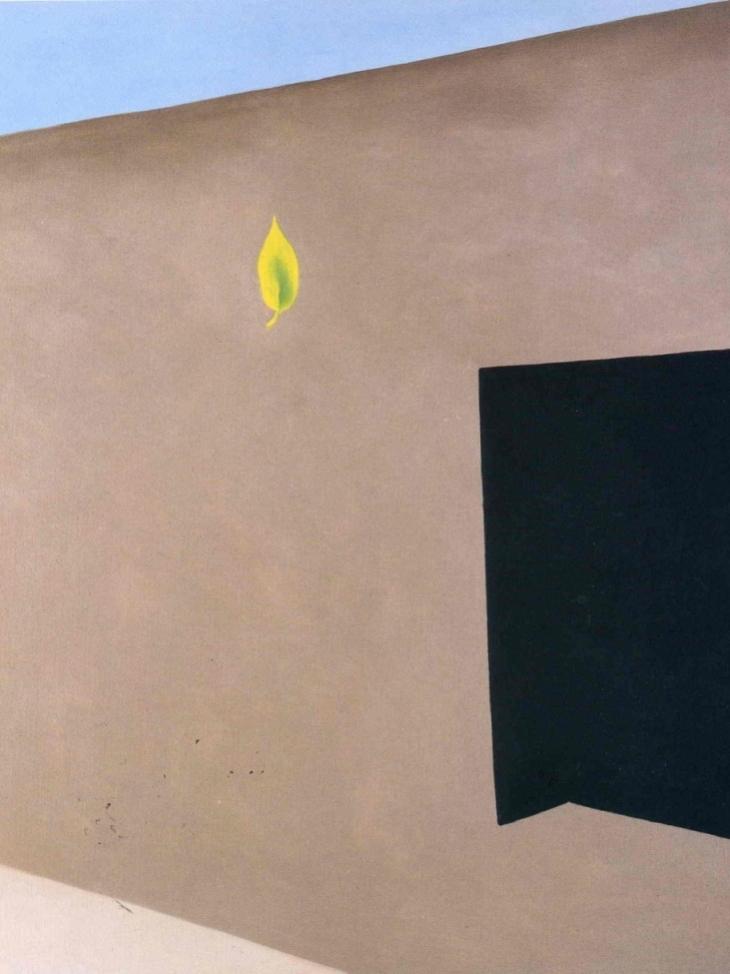 O'Keeffe painting: an adobe wall with a black opening and a single yellow leaf