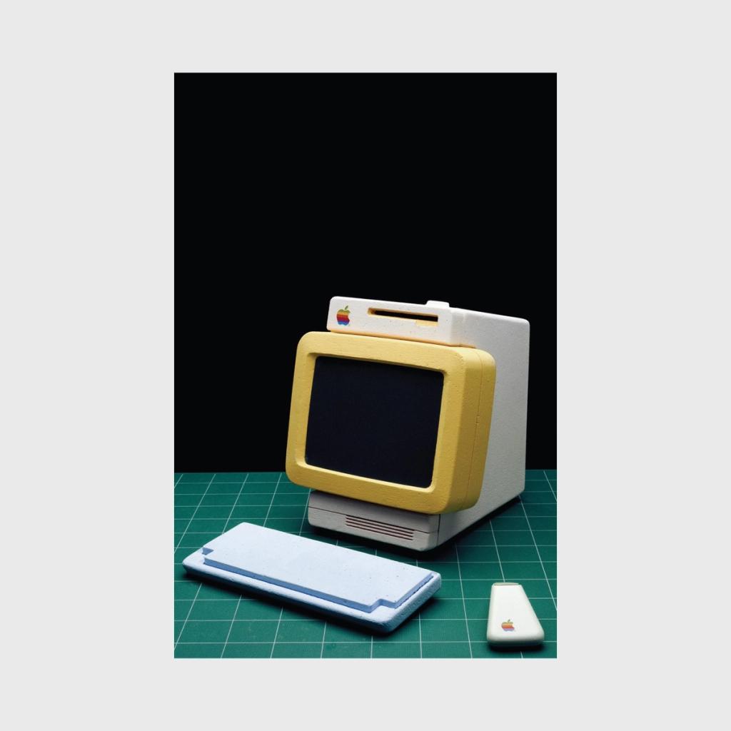 An Apple computer concept with a yellow screen bezel, white keyboard and mouse
