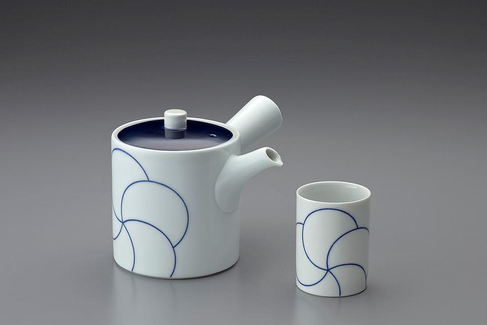 White teapot and cup with a blue linear pattern of concentric circles