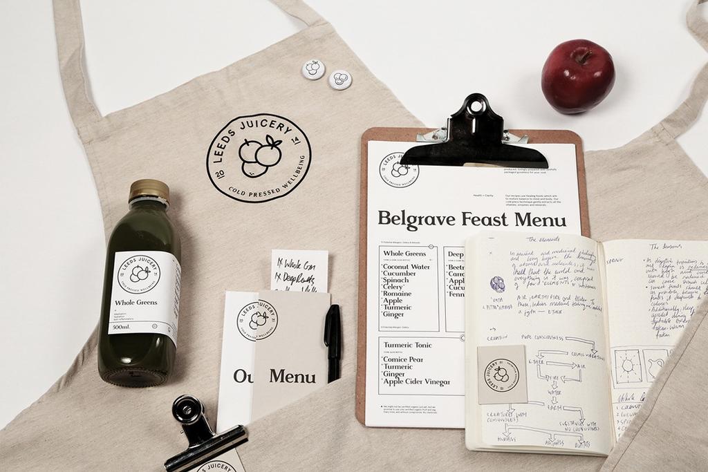 Фартук с логотипом Leeds Juicery, бутылка сока, меню и блокнот