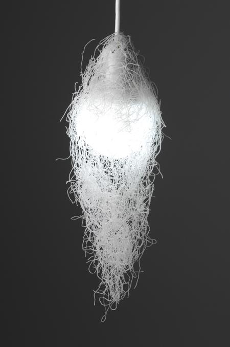 Pendant lamp made of interwoven white threads around a glowing sphere