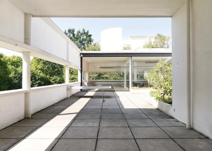 The open roof terrace of Villa Savoye with a concrete parapet and greenery