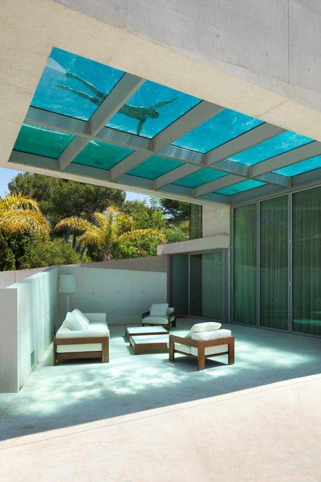 Стеклянное дно бассейна Jellyfish House с плывущим человеком над бетонной террасой