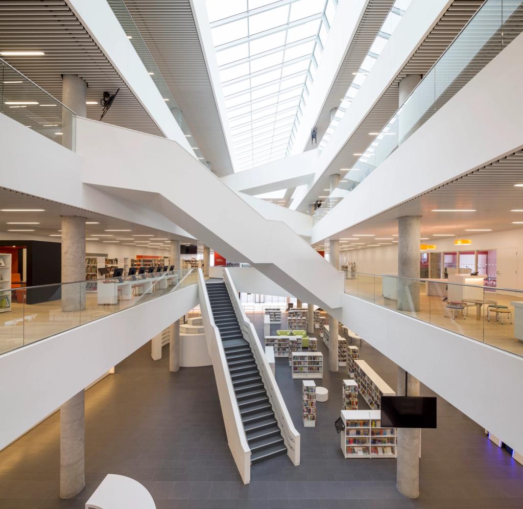 The bright multi-storey atrium of the Halifax library with intersecting white staircases beneath a rooflight
