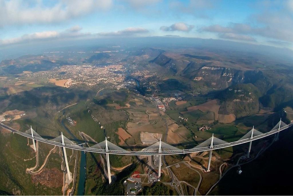 An aerial view of the Millau Viaduct over the river and valley fields