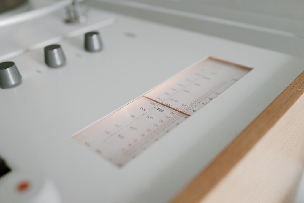 The radio tuning scale with its graduations and tone knobs on the Braun panel