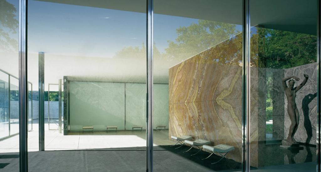 Interior of the Barcelona Pavilion featuring an onyx wall, glass and a bronze sculpture